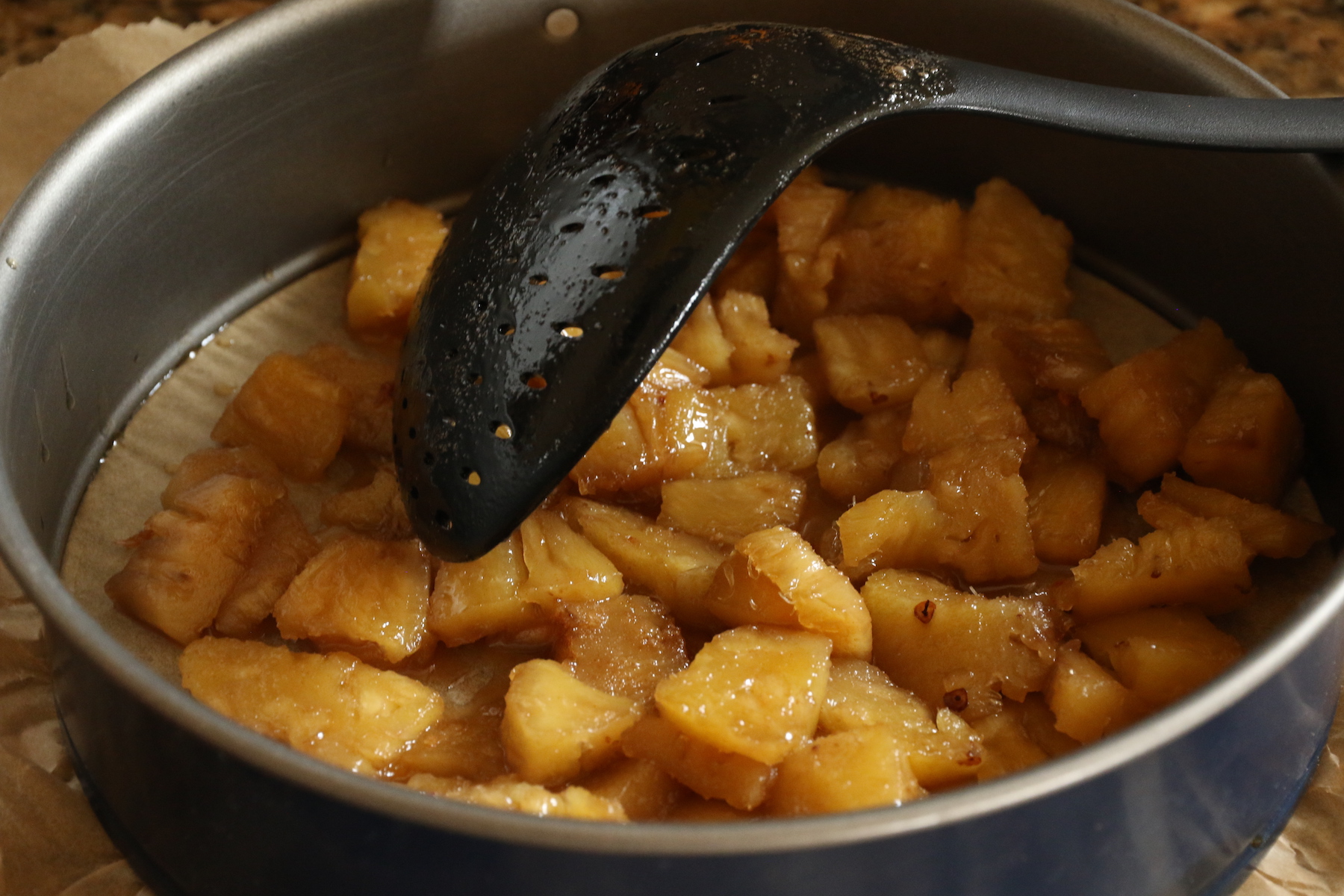 Hors du feu, retirer les ananas avec une écumoire et les répartir au fond du moule